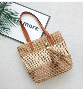 Modische ausgehöhlte Stroh-Umhängetasche im Farbblock-Design Strandtasche mit Quasten-Anhänger.