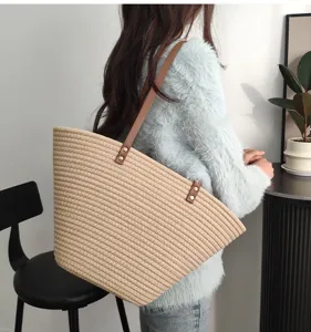 Detailaufnahme der gewebten Stroh Umhängetasche mit braunen Lederriemen für Damen.