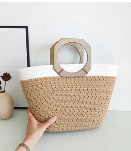 Vista detallada de un bolso tote elegante tejido de cuerda de algodón con asas de madera.