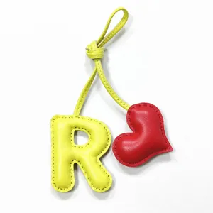 Ciondolo per borsa lettera R in pelle fatta a mano e cuore rosso, accessorio portachiavi elegante.