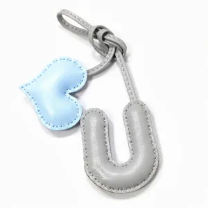 Nahaufnahme des handgefertigten Lederbuchstaben U Taschenanhängers mit blauem Herz.