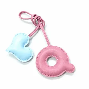 Detaillierter handgefertigter Leder Herz und Q Anhänger Detail in schönem rosa blau.