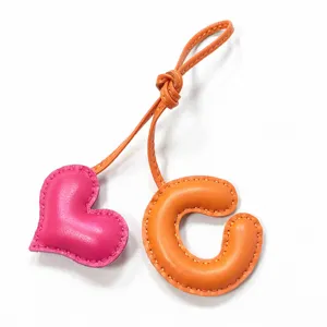 Colgante de bolso de cuero hecho a mano con letra C y corazón, accesorio elegante.