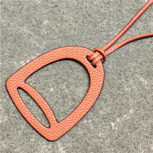 Oranger Leder Steigbügel Taschenanhänger, stilvolles hohles Deko-Accessoire für Handtaschen.