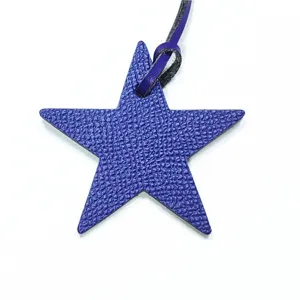 Vue rapprochée détaillée du charm de sac en cuir étoile violette avec une lanière.