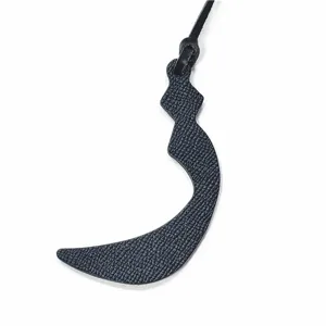 Detailed close-up of a premium leather Arabic letter bag charm with exquisite stitching and strap.