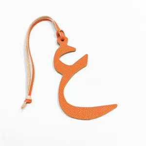 Orange leather Arabic letter bag charm detail view, exquisite craftsmanship and stitching.