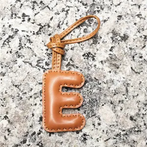 Light brown leather letter E bag charm, stylish initial pendant for women's handbags and car keys.
