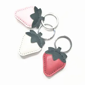 Detailed view of cute leather strawberry keychain bag charm in lovely pink, white and red colors.