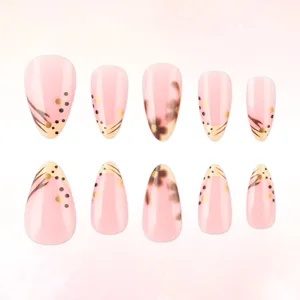 Vue détaillée des faux ongles rose nude avec des motifs floraux élégants et pois dorés.