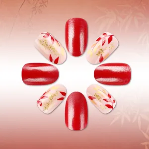 Autumn winter short almond press on nails with red glitter and gold leaf design detail.