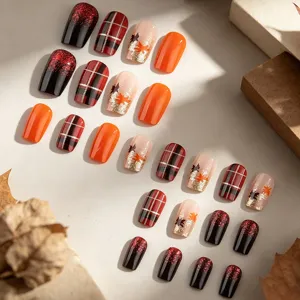 Detailed view of autumn press-on nails featuring plaid, maple leaves, and glitter designs.