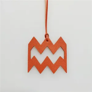 Detailed close-up of the orange leather Aquarius zodiac charm with unique geometric design.