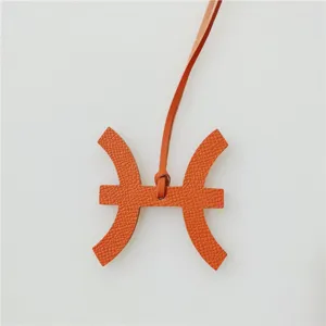 Sterrenbeeld Vissen lederen tasbedel in klassieke oranje kleur, stijlvol handtas accessoire.