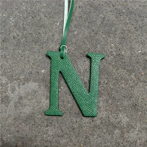 Green leather letter N bag charm detailed view, stylish alphabet accessory for women.