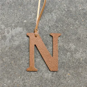 Brown leather letter N bag charm with strap, elegant accessory for women's handbags.