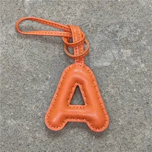 Charm de sac lettre A en cuir orange, charmant pendentif initial détail du produit.