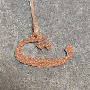 Arabic letter bag charm detailed view, brown leather pendant accessory for women handbags.