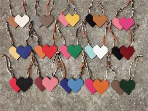 Detail view of two-tone leather heart bag charms with colorful patterned straps, candy colors.