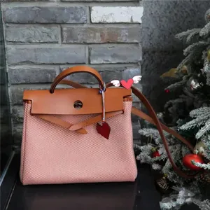 Canvas leather handbag detail shot featuring classic turn lock closure and top handle design.