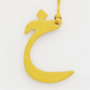 Yellow leather Arabic letter bag charm, premium texture accessory for keys and purses.