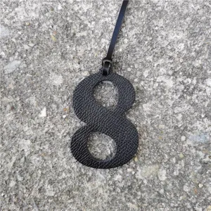 Black leather texture number 8 bag charm pendant detail shot, stylish DIY accessory decor.