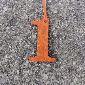 Orange leather number 1 bag charm detail shot, stylish DIY accessory close-up display.