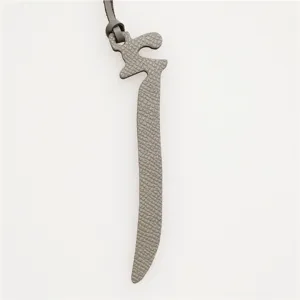 Elegant leather Arabic letter bag charm and luxury car key pendant in premium texture.