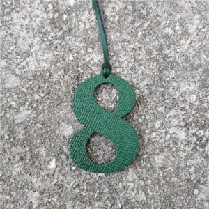 Green embossed leather number 8 bag charm close-up detail pendant DIY accessory for styling.