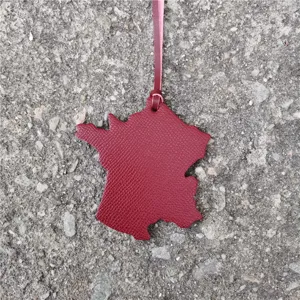 France map leather bag pendant detail shot, stylish car charm and accessory for bags.