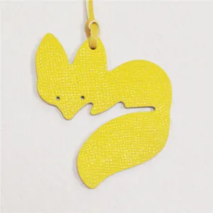 Close-up of the yellow leather fox bag charm detail, showing fine texture and cute shape.