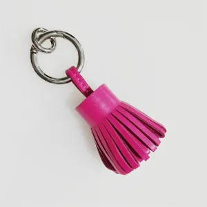 Primer plano de llavero con borla de cuero genuino, anillo metálico elegante y accesorio.