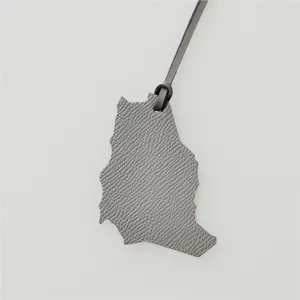 Grijs leer kaart vorm bedel detail, elegante tas hanger of auto ophang accessoire.