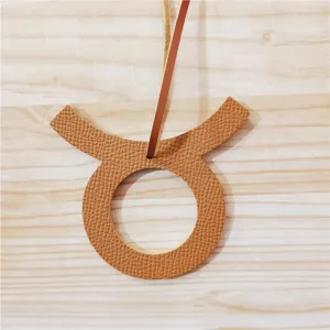 Close-up detail van de bruine lederen Stier dierenriem teken tas hanger textuur en riem.