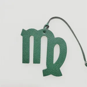 Virgo constellation leather bag charm detail shot, elegant green textured accessory for daily use.