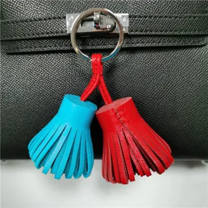 Two-tone leather tassel bag charm detail, vibrant blue and red keychain pendant for handbags.