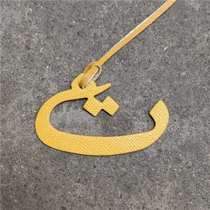 Yellow leather Arabic letter bag charm, chic handbag pendant accessory for women, stylish purse decor.