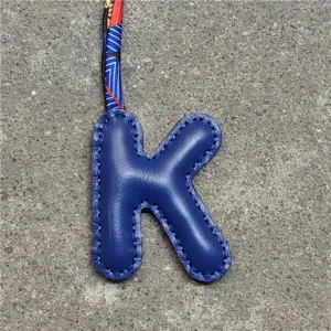 Blauer Leder Buchstabe K Taschenanhänger Detail mit buntem Seidentuch Band, Anhänger.