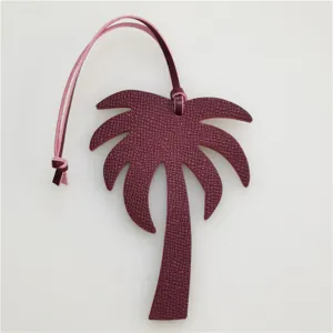 Detailed view of a stylish burgundy palm tree leather bag charm pendant with pink strap.