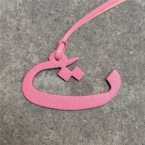 Pink leather Arabic letter bag charm pendant, stylish luxury accessory for women's handbags.