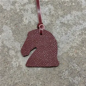 Vue détaillée du charm de sac tête de cheval en cuir texturé, fabrication artisanale raffinée.