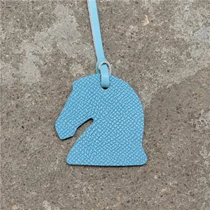 Mini charm's de sac tête de cheval en cuir bleu clair, gros plan du pendentif texturé.