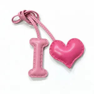 Pink leather letter I and heart charm detail shot, handmade stitching bag pendant accessory.