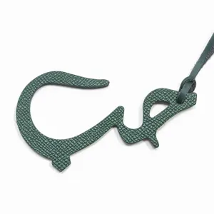 Vue détaillée du charm de sac en cuir vert lettre arabe et pendentif de décoration auto.