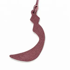 Detailed close-up shot of a dark red leather Arabic letter bag charm with matching strap.