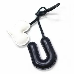 Handgefertigter Leder Buchstabe U und Herz Taschenanhänger, exquisite Nähte für Handtaschendekoration.