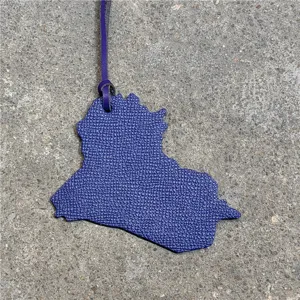 Close-up detail view of the purple leather Iraq map country shape bag charm pendant.