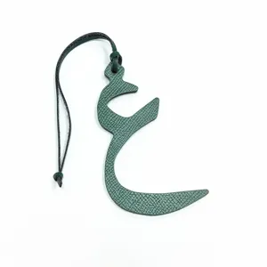 Dark green leather Arabic letter bag charm, stylish purse accessory with black leather strap.