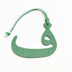 Colgante de bolso de cuero verde con letra árabe, elegante accesorio en miniatura.