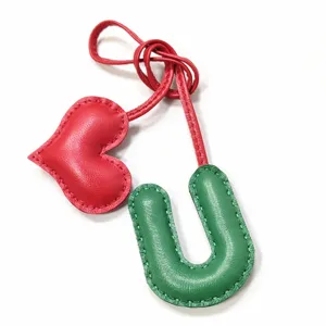 Handgefertigter Leder Buchstabe U und Herz Taschenanhänger mit präzisen Ziernähten.